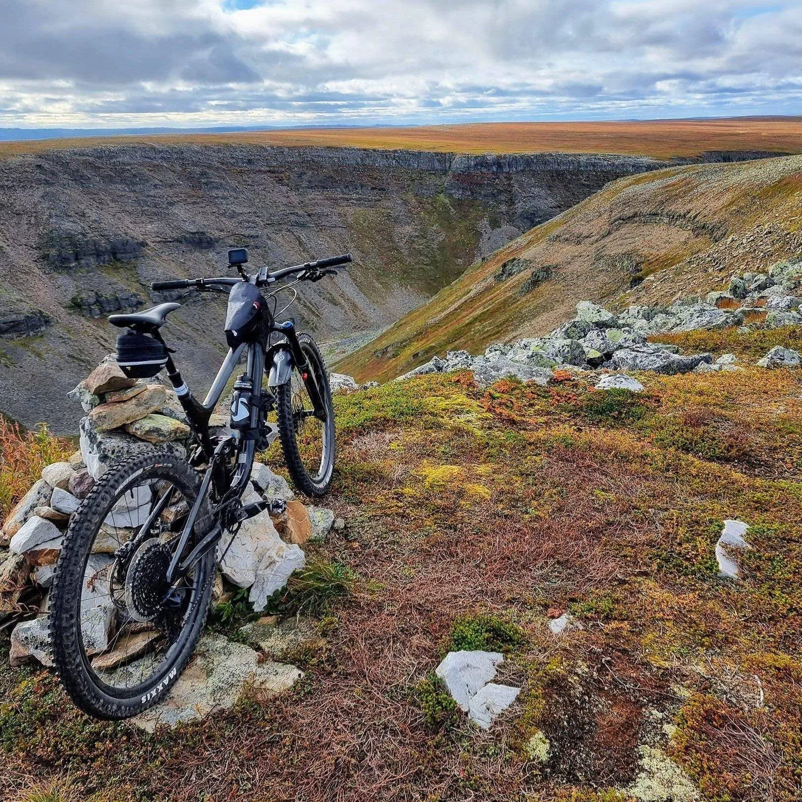 Sykkel ved varde over canyon på Varangerhalvøya