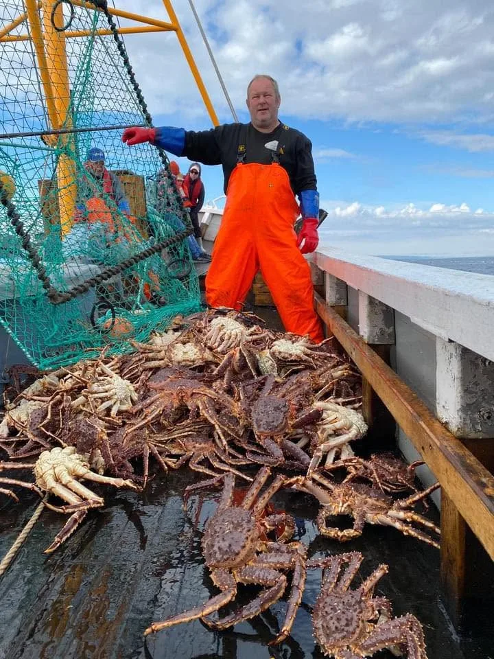 Fisker med kongekrabbe på båtdekk